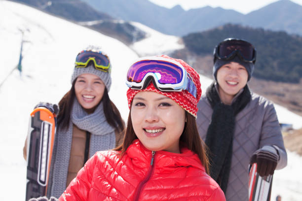 istock Chinese friends standing on ski slope with skis 1083472598