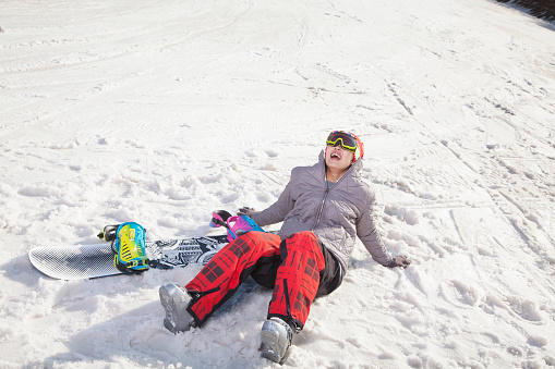 Chinese snowboarder sitting in snow