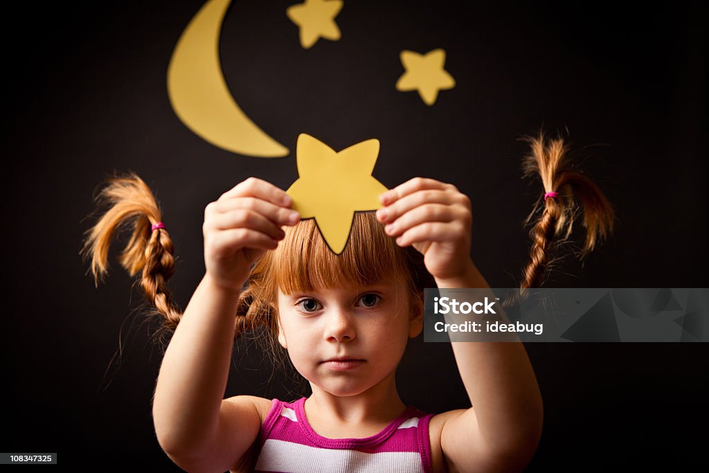 Menina com tranças em pé sob a lua para cima segurando estrelas - Foto de stock de Criança royalty-free