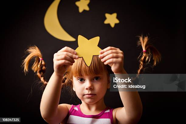 Foto de Menina Com Tranças Em Pé Sob A Lua Para Cima Segurando Estrelas e mais fotos de stock de Criança