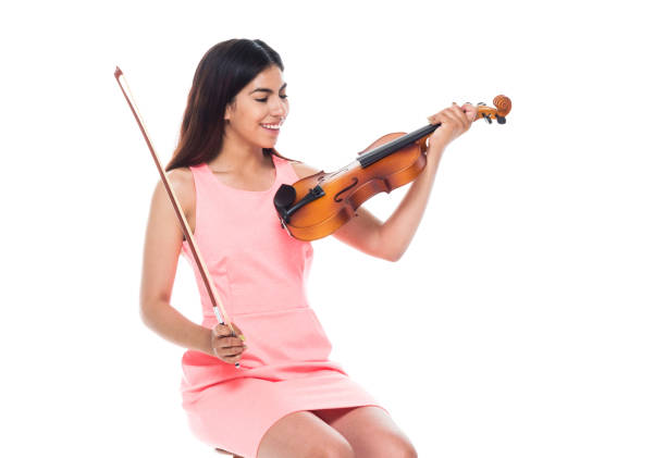 istock Attractive young latino female playing the violin while sitting on stool 1083474920