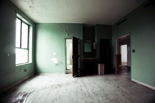 Empty room in an abandoned hospital.  Doors open and leading to another creepy room.