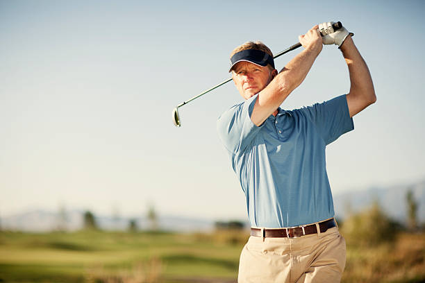 Golf Swing A middle-aged golfer swinging for the green. Just add type for the perfect golfing image. golf concentration stock pictures, royalty-free photos & images