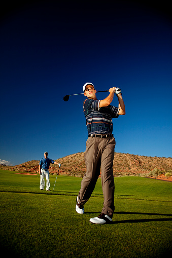 A male golfer goes for the perfect tee shot. Just add type for the perfect golfing image.