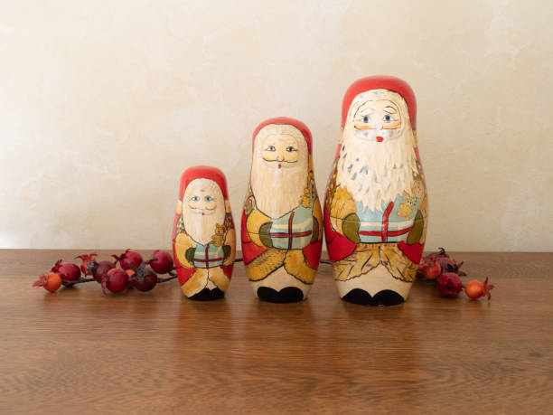 drei hölzerne santa nesting dolls und beeren - russian nesting doll small group of objects wood doll stock-fotos und bilder