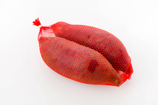 istock Raw Japanese sweet potatoes in a net bag on white background 1083478686