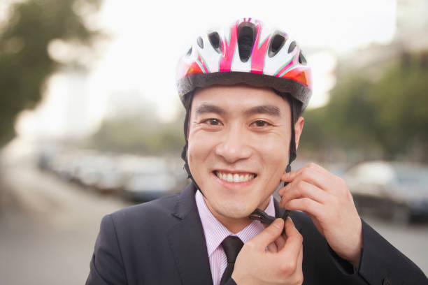 istock Chinese man putting on bicycle helmet 1083480674