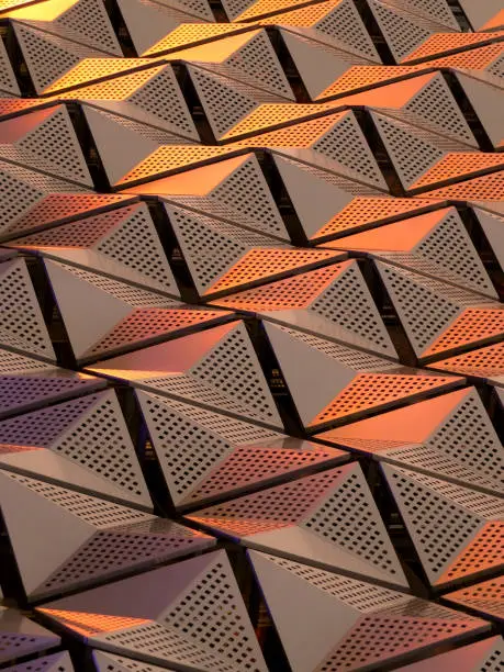 metallic geometric architectural cladding or panels in copper and gold colours with repeating angular pattern