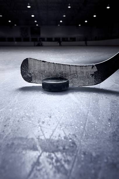 Hockey Stick and Puck A dramatic close up of a hockey stick and puck from a surface level view on the ice. There is ample space for copy. traditional sport stock pictures, royalty-free photos & images