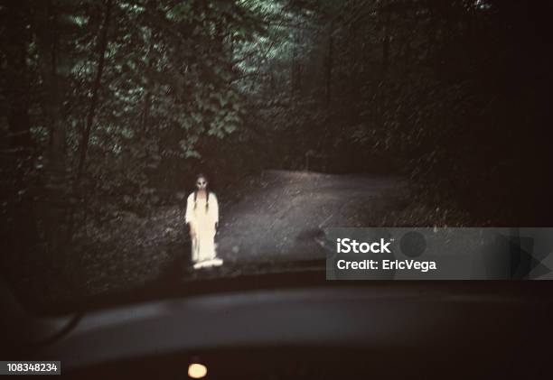 Spooky Ghost In White Standing In The Middle Of A Dark Road Stock Photo - Download Image Now