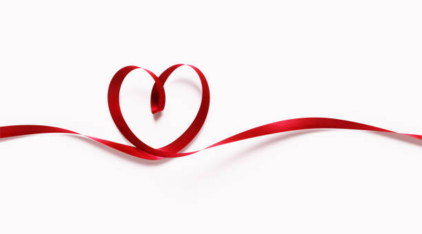 красная лента формирование формы сердца на белом фоне - день святого валентина концепция - лента символ борьбы со спидом стоковые фото и изображения