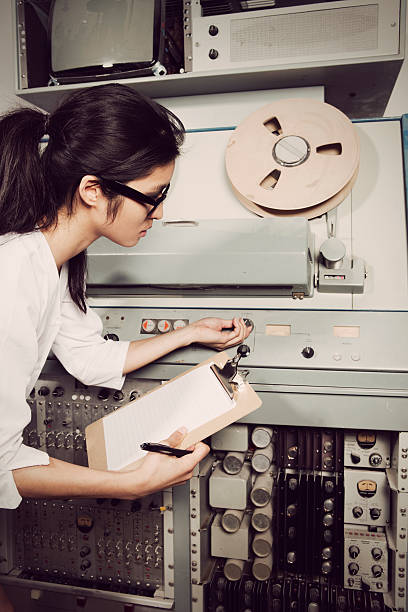 Young female scientist checking computer, 60s/70s vintage style stock photo