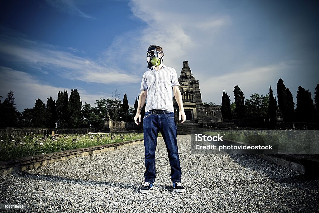 Homem com uma máscara de gás em um cemitério - Foto de stock de Gás natural royalty-free