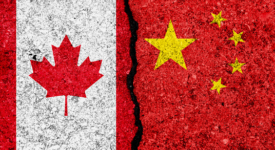 Flags of China and Canada painted on cracked grunge wall background/Canada and China relations and conflict concept