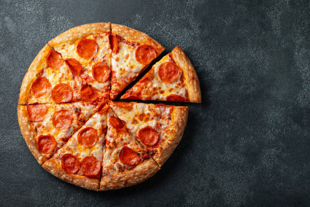 leckere peperoni-pizza und kochen zutaten tomaten basilikum auf schwarzem hintergrund beton. draufsicht der hot peperoni-pizza. mit textfreiraum für text. flach zu legen - scheibe portion fotos stock-fotos und bilder
