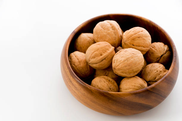 istock Walnut in a wooden bowl on a white background 1083490416