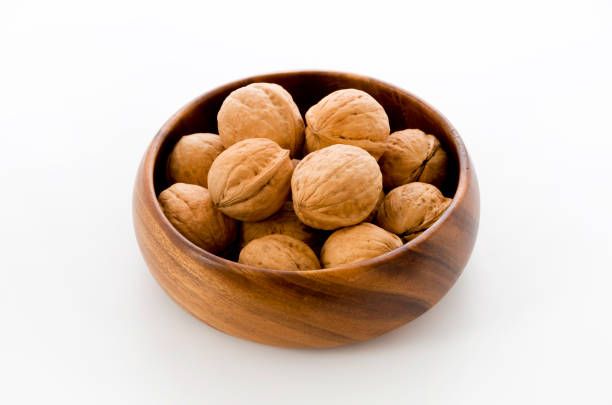 istock Walnut in a wooden bowl on a white background 1083490576