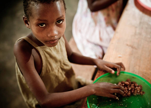 ragazza africana mangiare un pasto in the orphanage - povertà africa foto e immagini stock