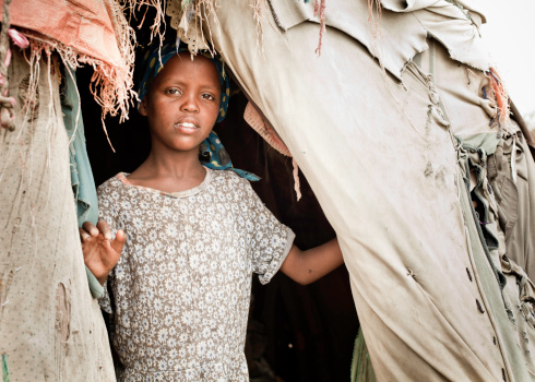 Omorate, Omo Valley, Ethiopia - May 11, 2019: Woman from African tribe Dasanesh with children in front of his hut. Daasanach are Cushitic ethnic group inhabiting in Ethiopia, Kenya, and South Sudan