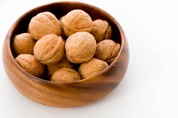 istock Walnut in a wooden bowl on a white background 1083492122