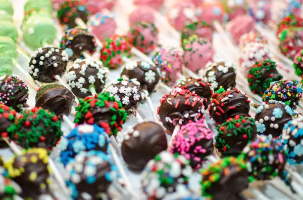 Selective focus on dozens of Christmas decorated chocolate cake pops lined up, homemade desserts for the holidays