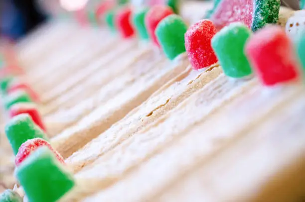 Abstract detail view of red and green Christmas gumdrop candy, useful for backgrounds. Intentional selective focus on one gumdrop