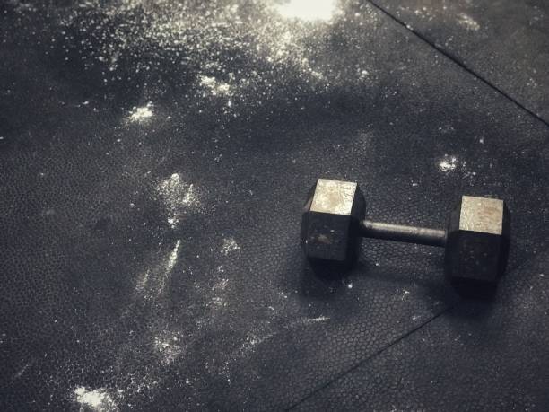Fitness Background Fitness background of gym floor with chalk dust and a dumbbell crossfit chalk weightlifting weight training stock pictures, royalty-free photos & images