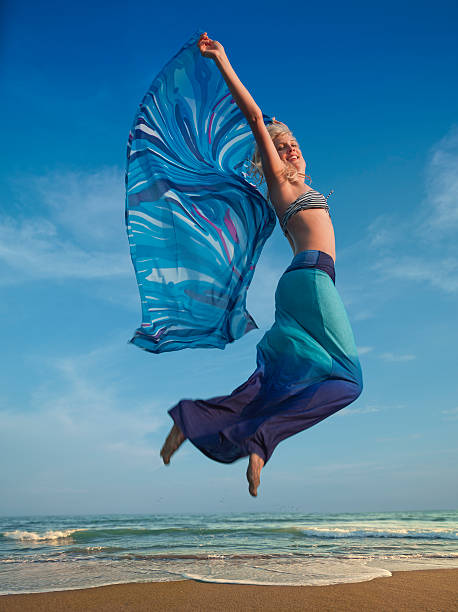 istock attractive blonde jumping on the beach 108349637