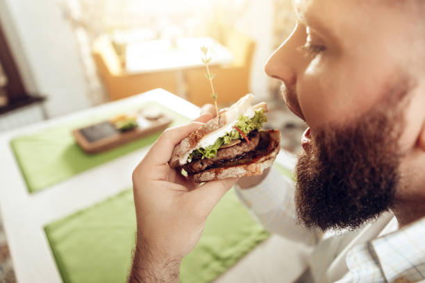 istock Back view man bite sandwich eating in cafe 1083497828