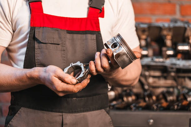 istock auto maintenance station. mechanic holding piston in hands. engine repair. 1083498468