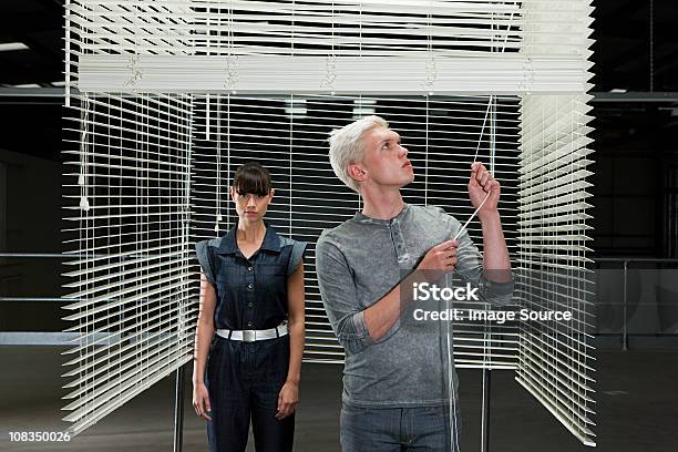 Young Couple Behind Venetian Blind Man Closing Blind 20-24세에 대한 스톡 사진 및 기타 이미지