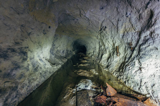 istock Water reflections inside dark dirty flooded abandoned mine 1083502158