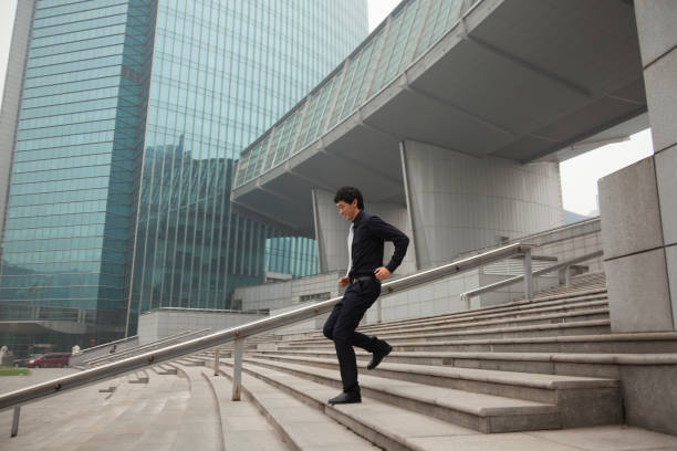 empresario chino sobre los pasos de la ciudad - running down fotografías e imágenes de stock