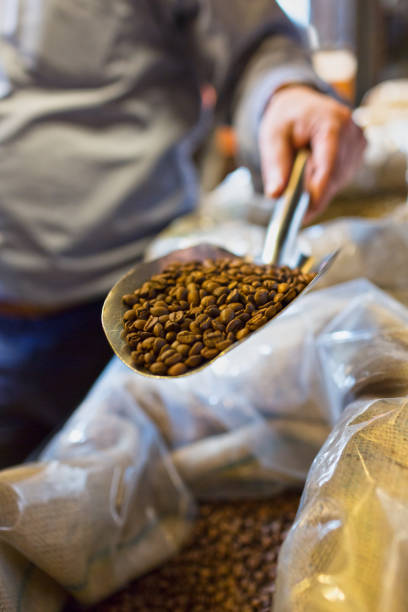istock Hand Holding a Scoop of Roasted Coffee Beans 1083502276
