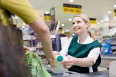 Female cashier and customer at supermarket checkout