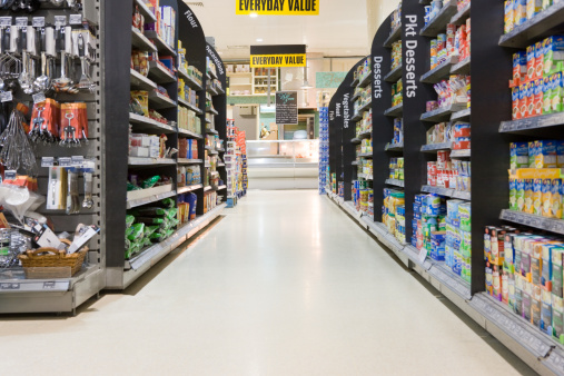 Supermarket aisle with shelfs full of a variety of products