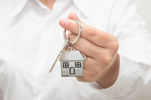istock Woman hand holding house model and key 1083505492