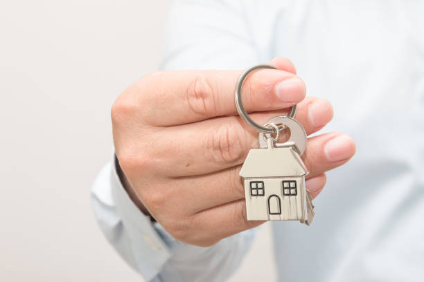 istock Man hand holding house model and key 1083505662