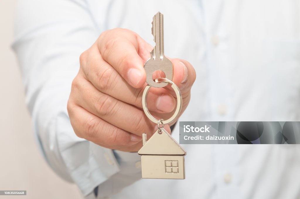 Mann Hand hält Hausmodell und Schlüssel - Lizenzfrei Aufschließen Stock-Foto
