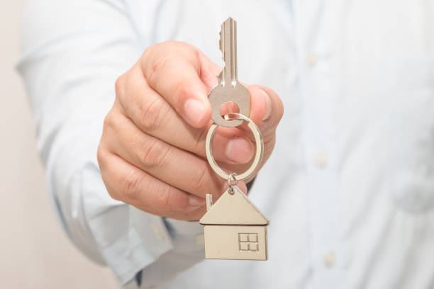 istock Man hand holding house model and key 1083505668