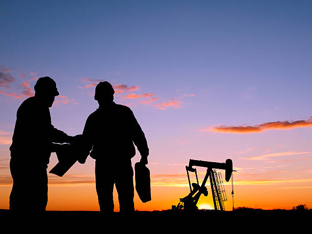 istock Silhouettes of workers and oil pump during sunset 108350747