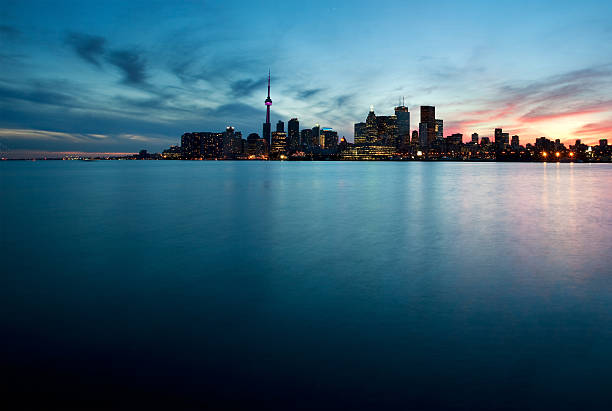 Toronto, Canada - View of the urban skyline from Polson Pier as sun sets behind city.