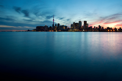 Toronto, Canada - View of the urban skyline from Polson Pier as sun sets behind city.