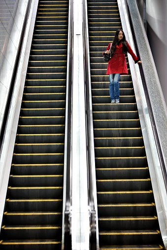 Cute asian woman at an escalator.