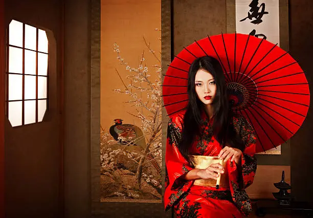 Beautiful Japanese geisha  with a red umbrella, Tokyo, Japan.