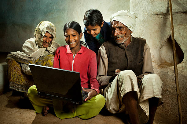 szczęśliwa wioska dziewczyna za pomocą laptopa z matką, brat i grandfa - senior adult women adult tan zdjęcia i obrazy z banku zdjęć