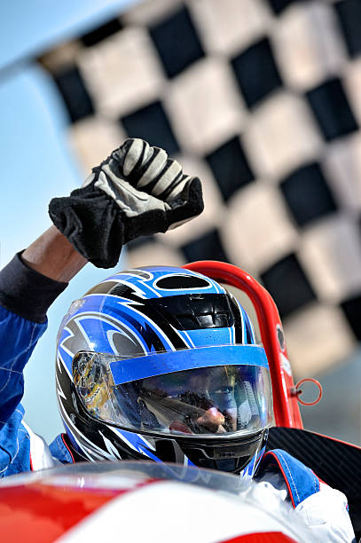 Winning racing driver against flag  race car driver stock pictures, royalty-free photos & images