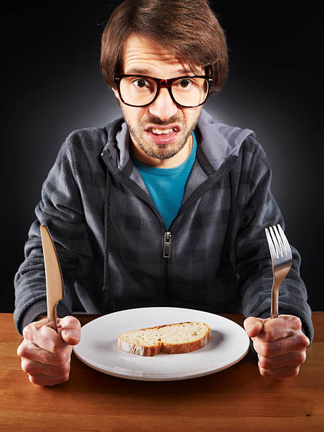 istock Unemployed young man, student must tighten the belt, eating bread 108351954