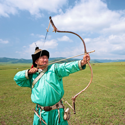 Mongolian archer standing on the grass, the blue sky on the background.http://bem.2be.pl/IS/mongolia_380.jpg