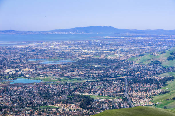 aerial view of fremont and other cities of east san francisco bay; san francisco and the bay bridge in the background; california - bay san francisco county residential district aerial view imagens e fotografias de stock